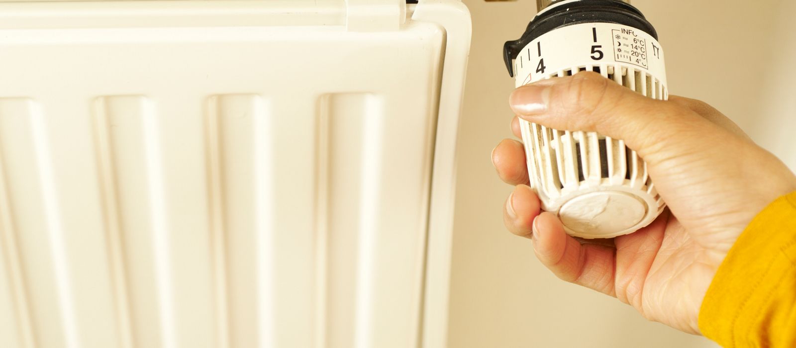 Hand turning a radiator thermostat valve