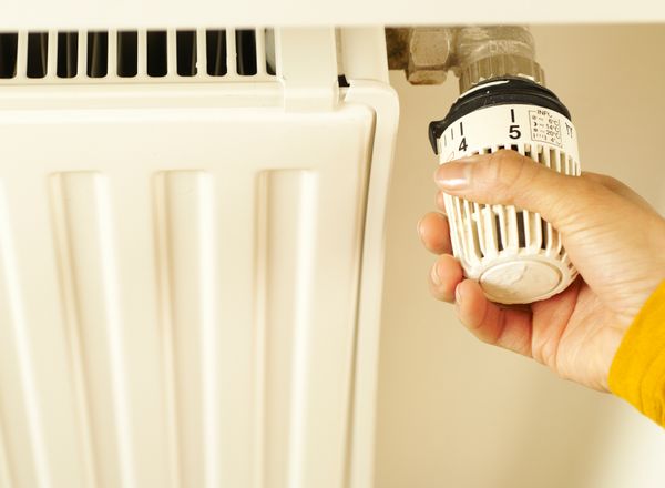 Hand turning a radiator thermostat valve