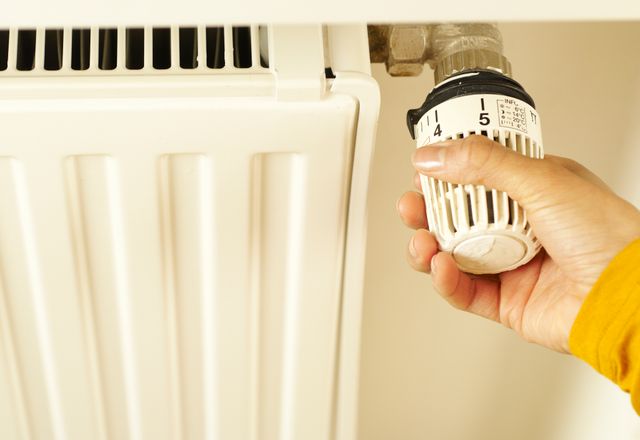 Hand turning a radiator thermostat valve