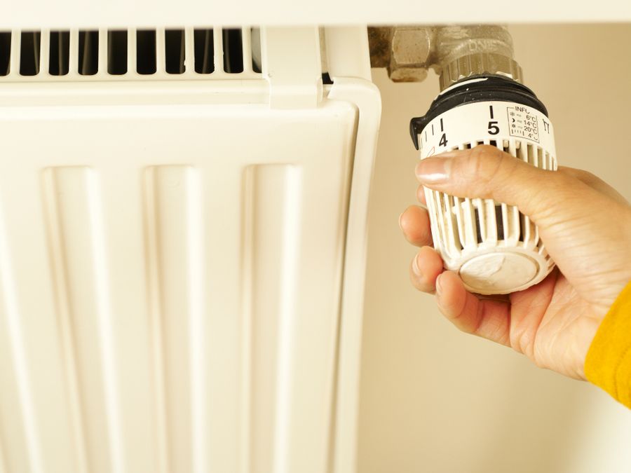 Hand adjusting a home heating control