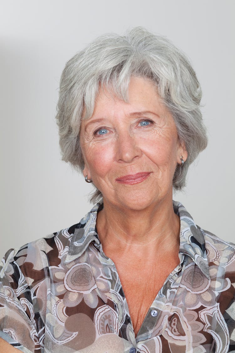 Portrait Of Elderly Woman On Grey Background