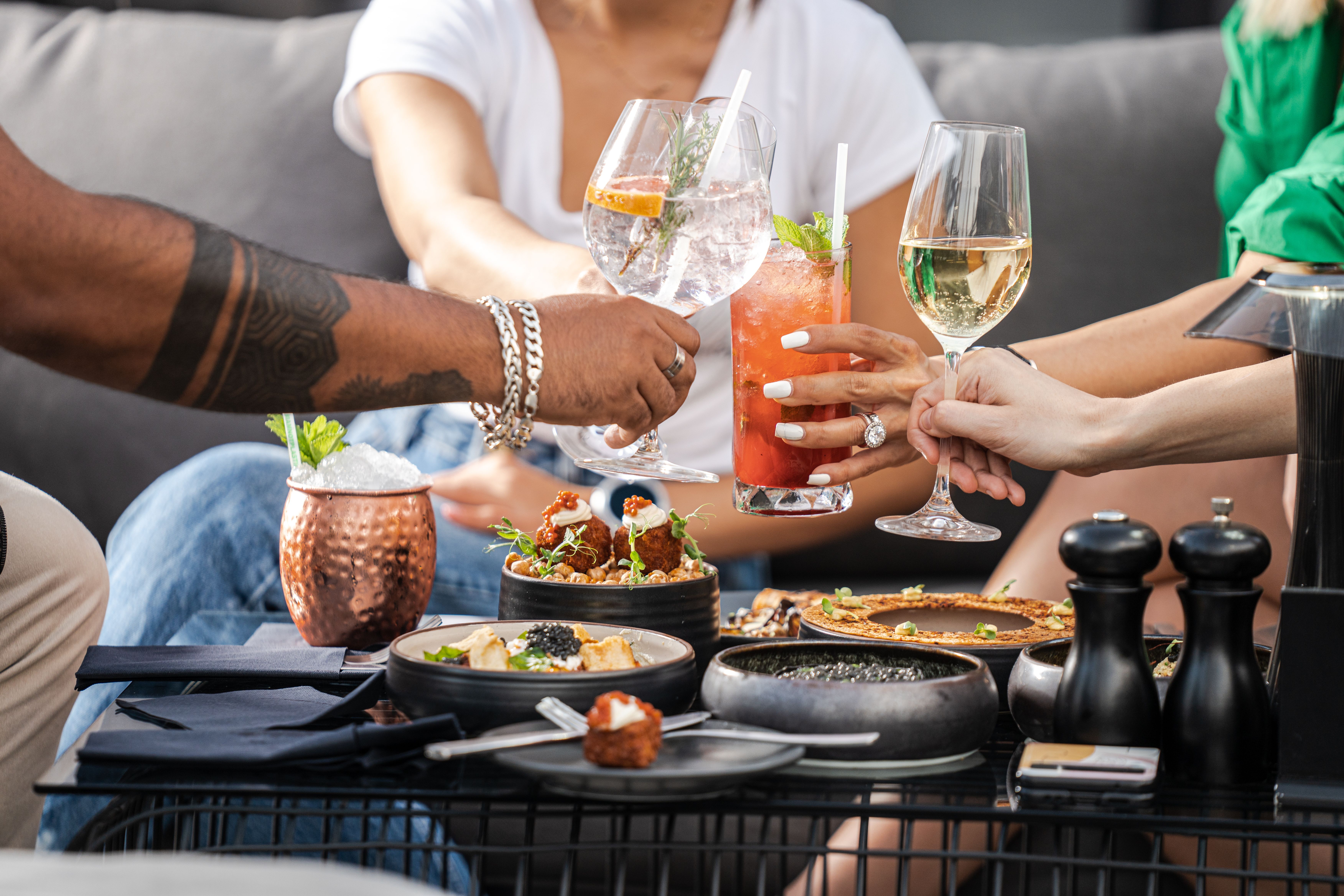 Friends drinking tropical cocktails together outdoors