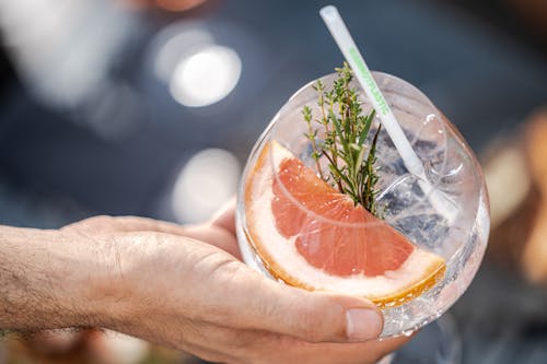 A Person Holding a Cocktail Glass with Straw