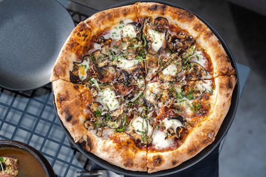 Close-up of a mouth-watering mushroom pizza with mozzarella and herbs on a rustic table.