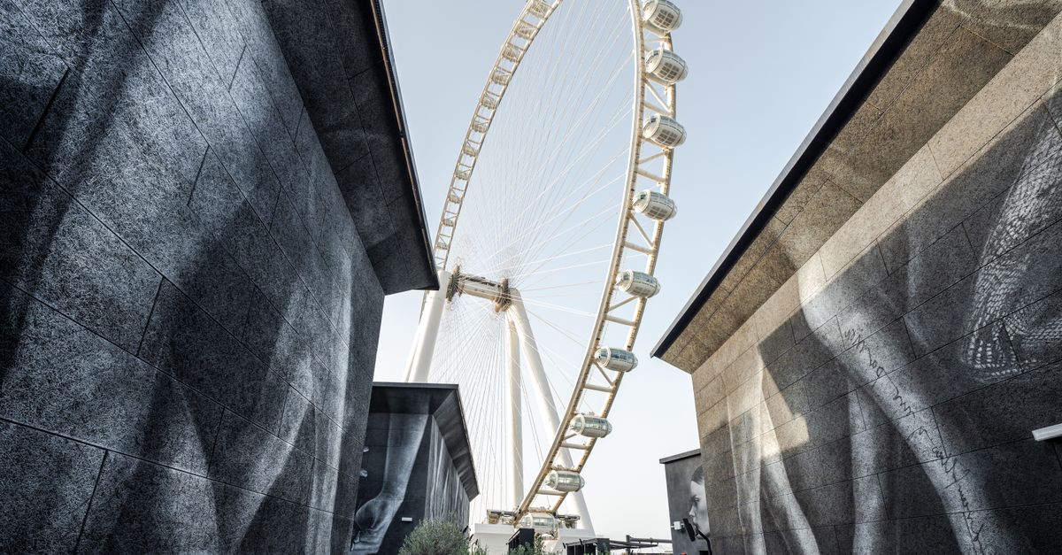 A modern urban perspective on Ain Dubai, the world's largest Ferris wheel, framed between architectu