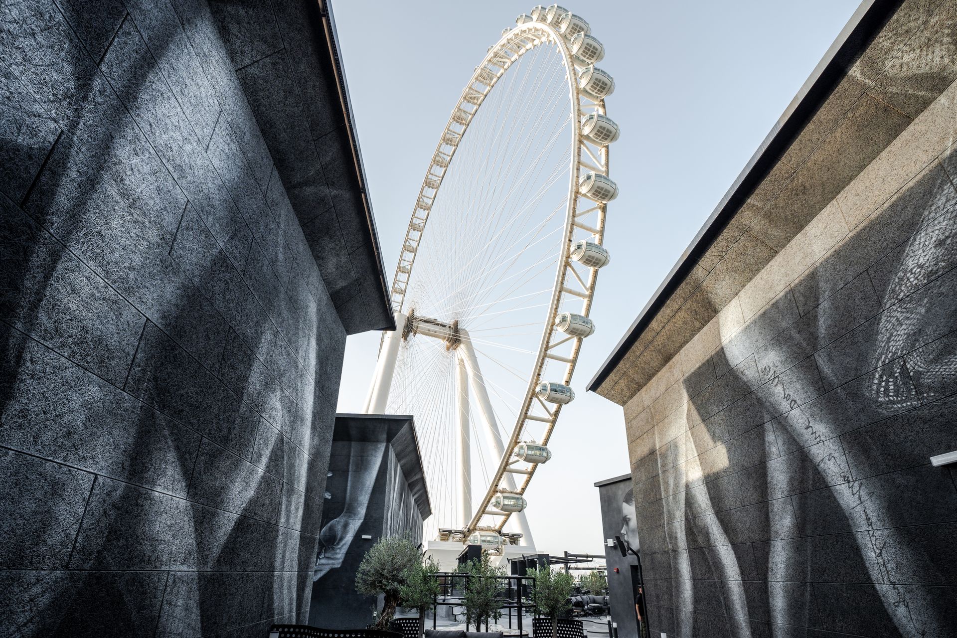 A modern urban perspective on Ain Dubai, the world's largest Ferris wheel, framed between architectu