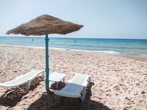 Free White Lounge Chair on Beach Stock Photo