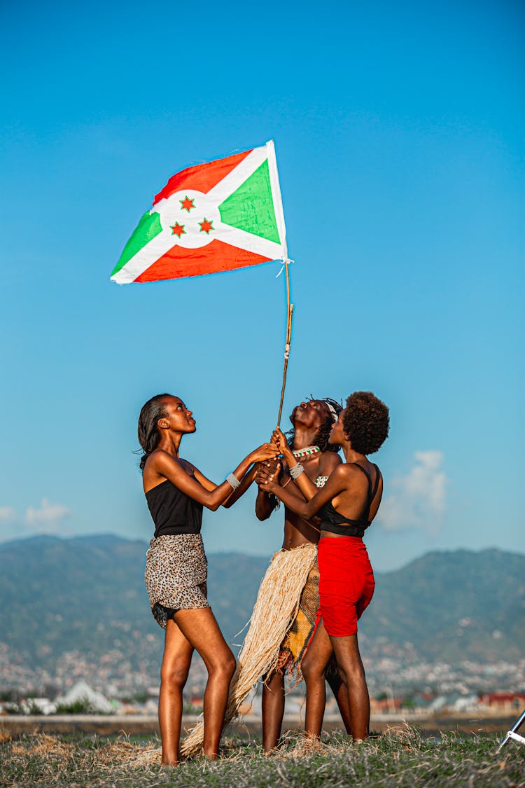 Group Of People Raising A Flag Together