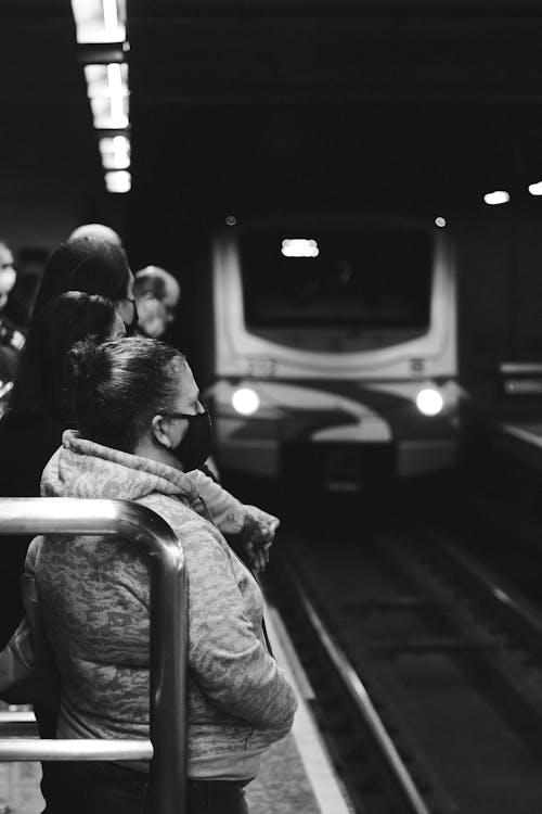 Black and White Photo of People Waiting in a Subway Station
