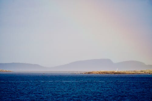 Free Body of Water Near Hazy Mountains Stock Photo