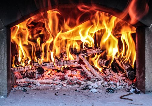 Captivating image of vibrant flames dancing across wood logs in a rustic fireplace.
