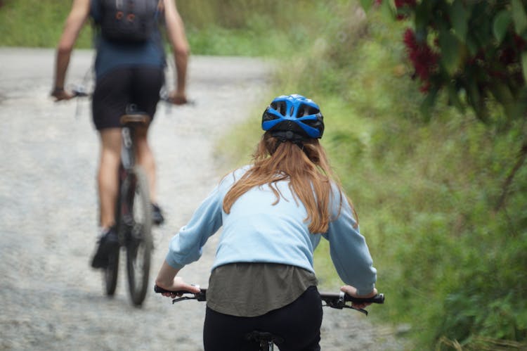 Woman Riding A Bike On Dirt Road