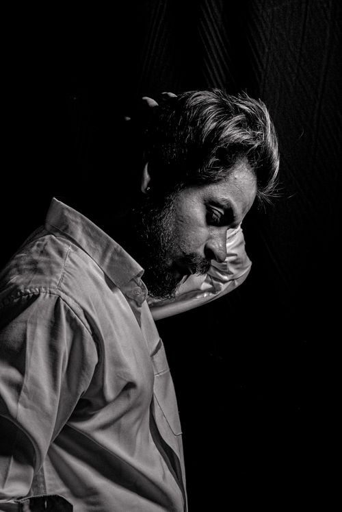 Free Expressive black-and-white portrait of a man in thoughtful pose with moody lighting. Stock Photo