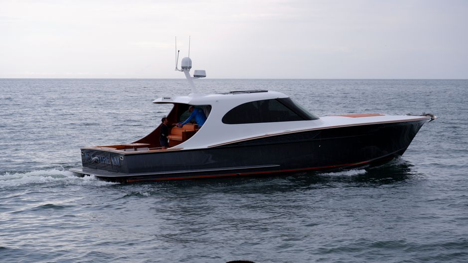 Sleek luxury yacht with individuals cruising freely on the open sea.