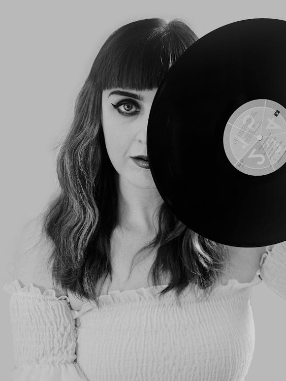 Free Black and White Portrait of a Woman Holding a Vinyl Record Stock Photo