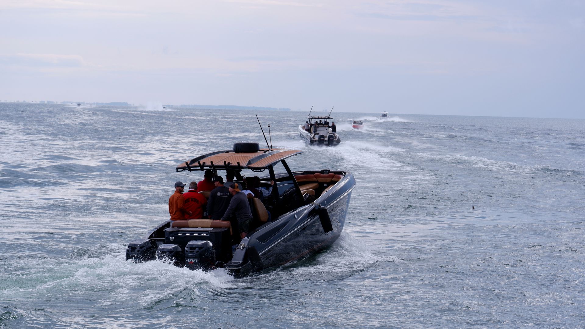 Motorboats sailing on open sea with visible passengers enjoying the ride.