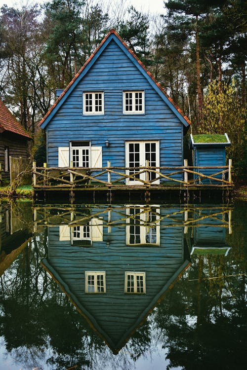 Blue and White Wooden House Beside a Lake