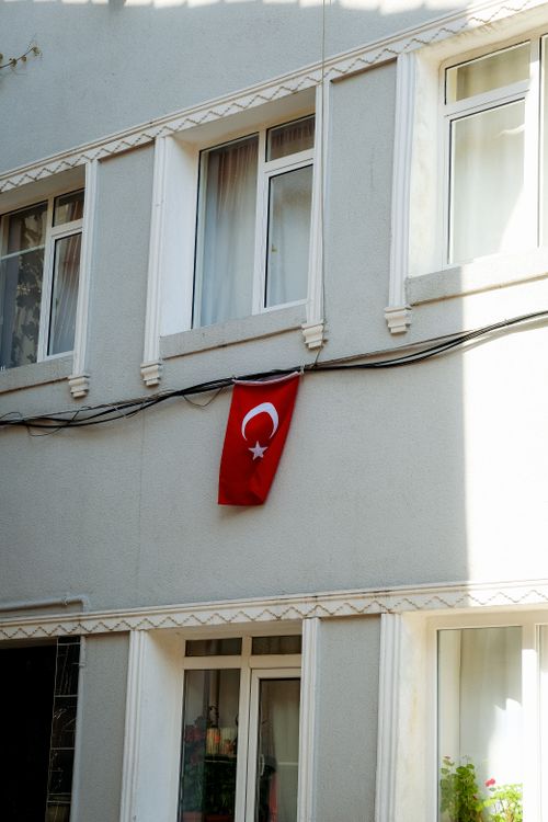 Free A Turkish flag displayed on a residential building facade reflecting urban architecture. Stock Photo