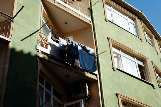 Laundry hanging on a sunny day from an apartment balcony.