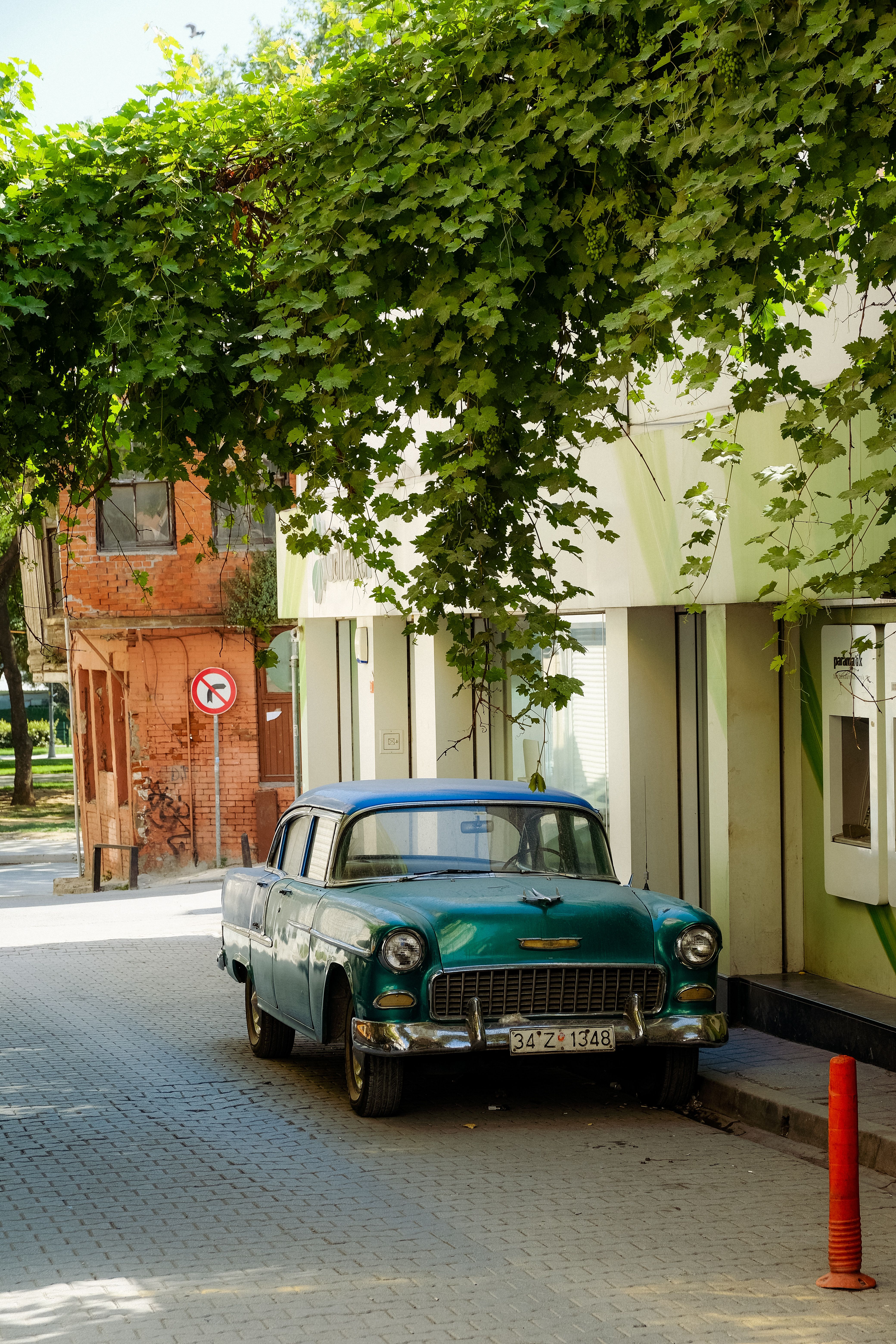 A Vintage Car Parked on the Side of a Cobblestone Street · Free Stock Photo