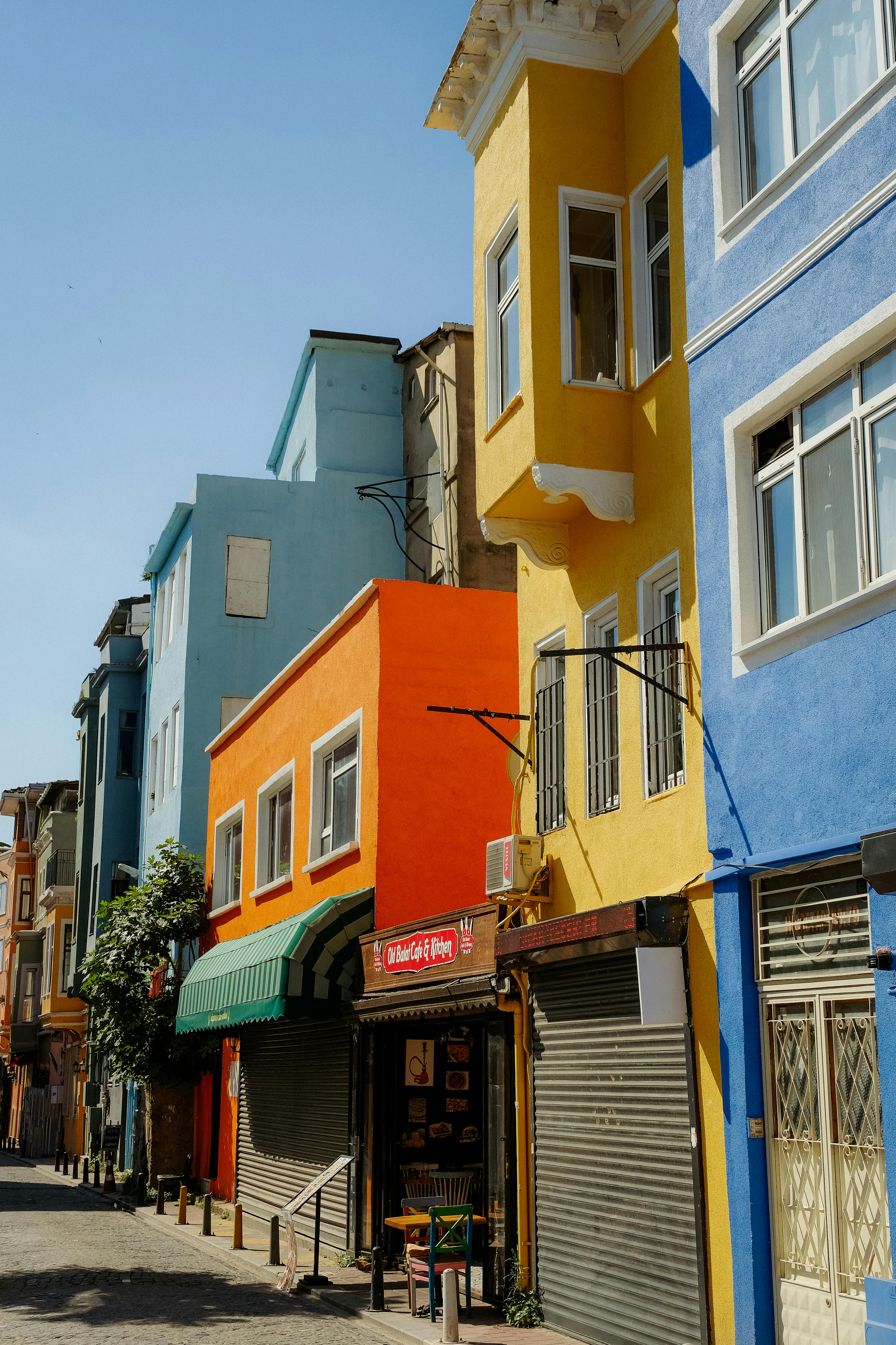 Free Vibrant facades of colorful houses in a city street corner under clear blue sky. Stock Photo
