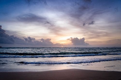 Free Serene beach scene capturing the ocean waves during a calming sunset. Stock Photo