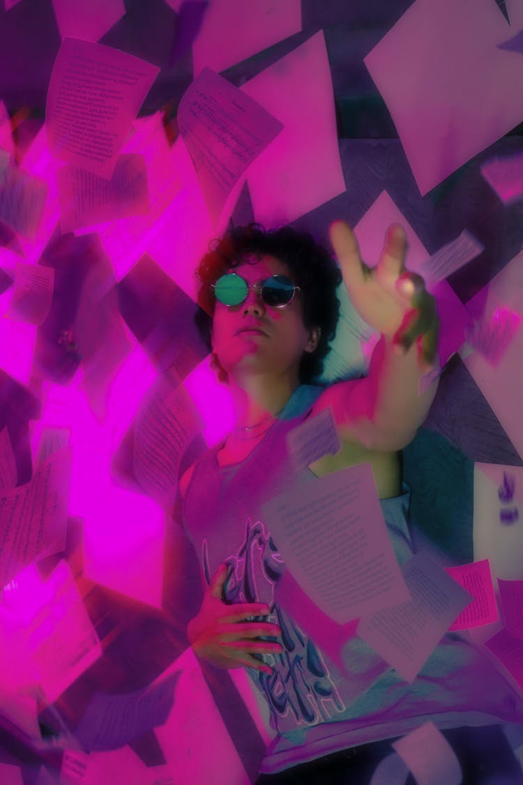 Man Posing Among Notes In Purple Light 