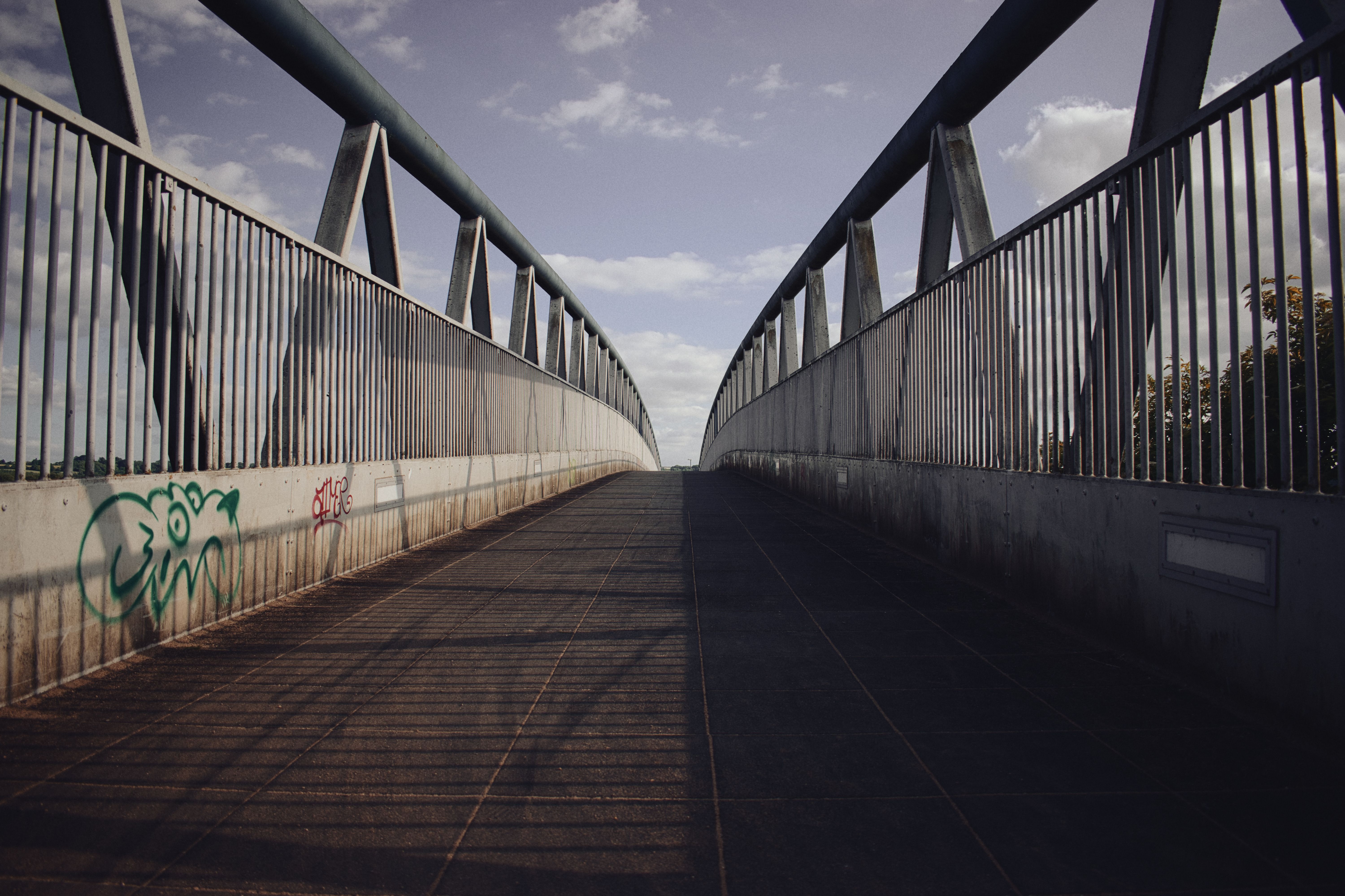 A modern metal footbridge in Wroughton, England, with a clear blue sky.