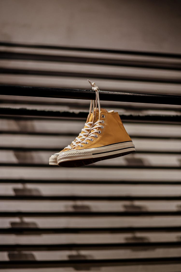 Converse All Star Sneaker Shoes Hanging On Metal Bar