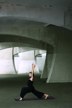 A woman performs yoga poses under a modern bridge structure focusing on fitness and tranquility.