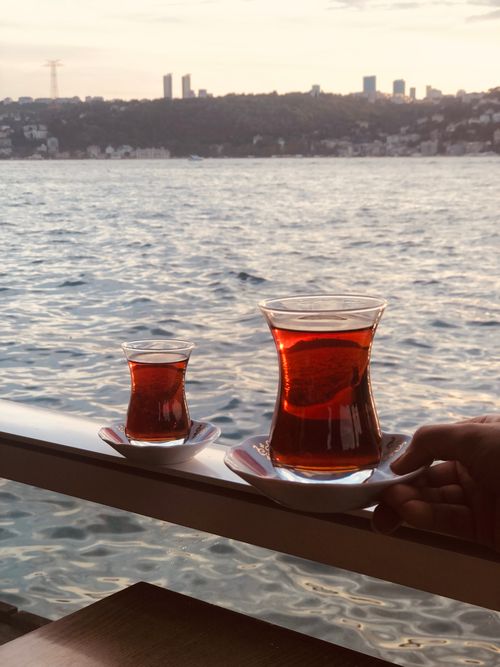 Free Savoring Turkish tea along the scenic seaside during a serene sunset. Perfect travel and lifestyle shot. Stock Photo