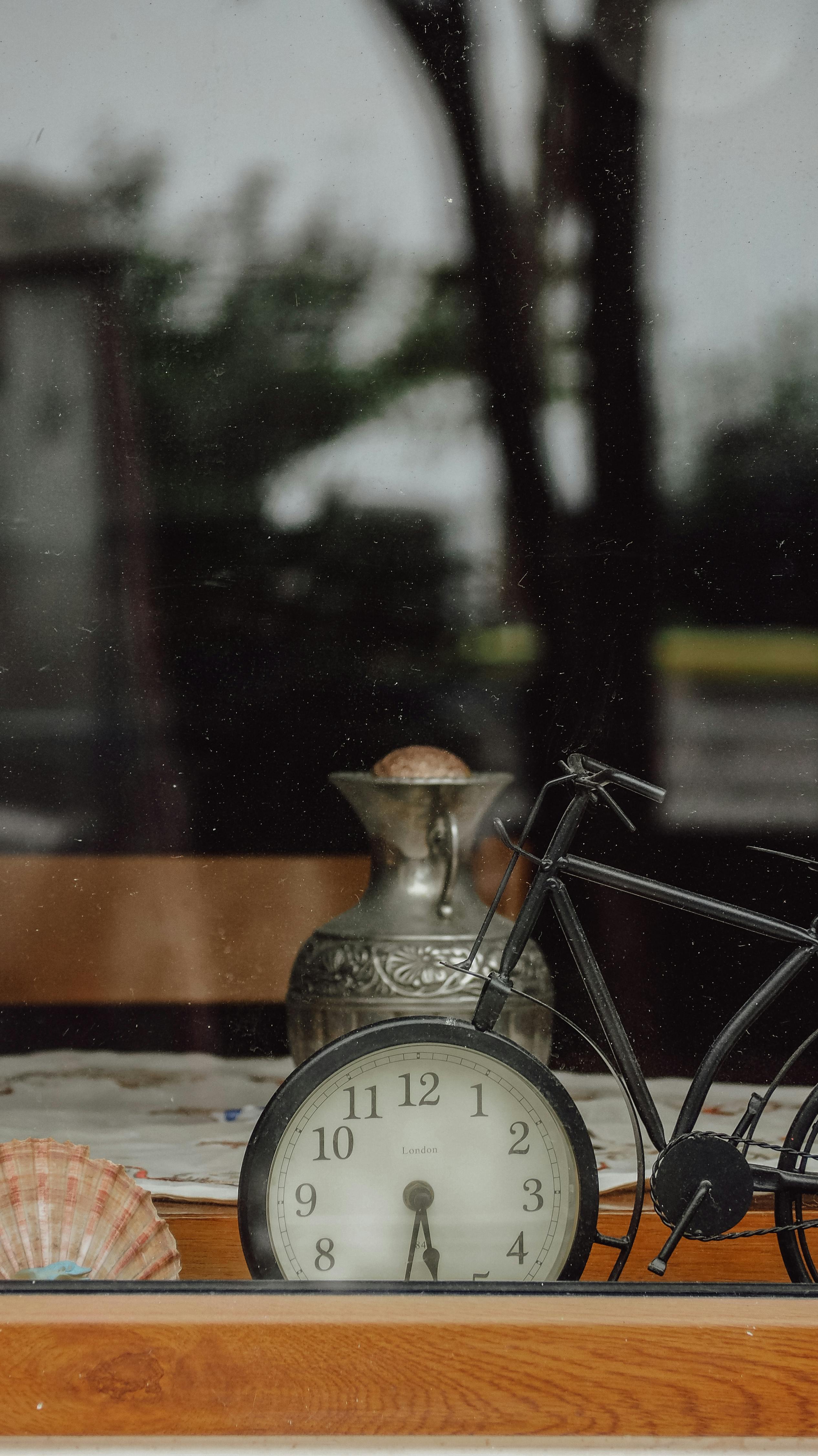 A vintage clock and metal bicycle ornament sit on a windowsill, providing a charming retro vibe.