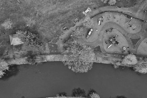 Free Aerial shot of a children's playground and river in a lush park in England. Stock Photo