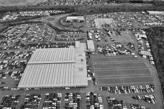 Wide-angle aerial shot showcasing busy parking lots and industrial buildings in England.