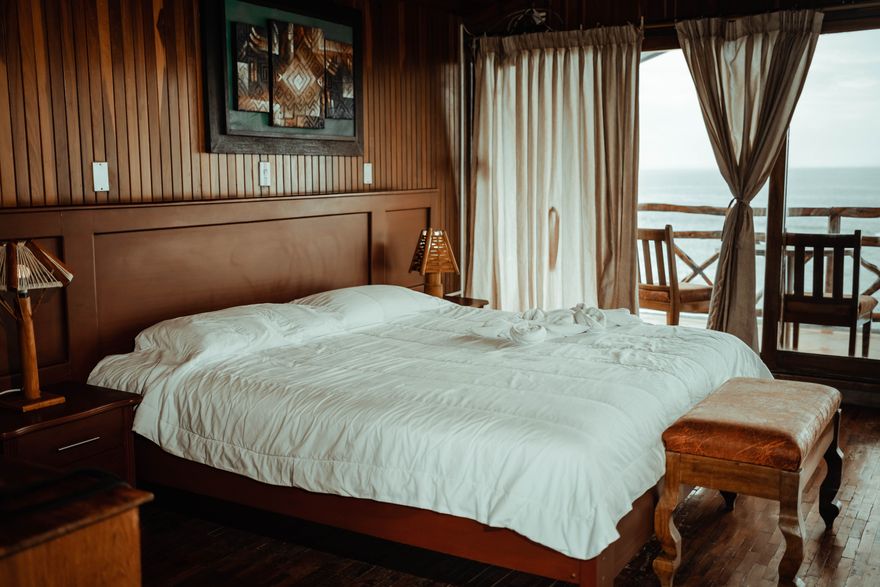 Guest suite with timber panelling and layered white bedding — photo by iam luisao on Pexels