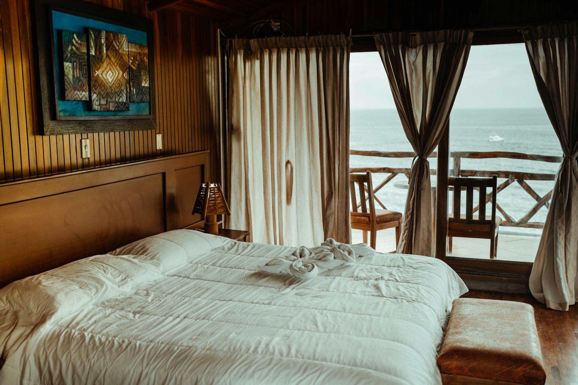 White Bed Linen Near Brown Wooden Bed Frame