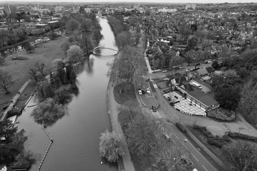 Free A scenic aerial shot of Bedford, UK, featuring the river, residential areas, and lush trees in black and white. Stock Photo