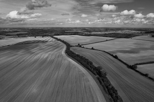 Aerial black and white view of expansive fields and countryside in England.