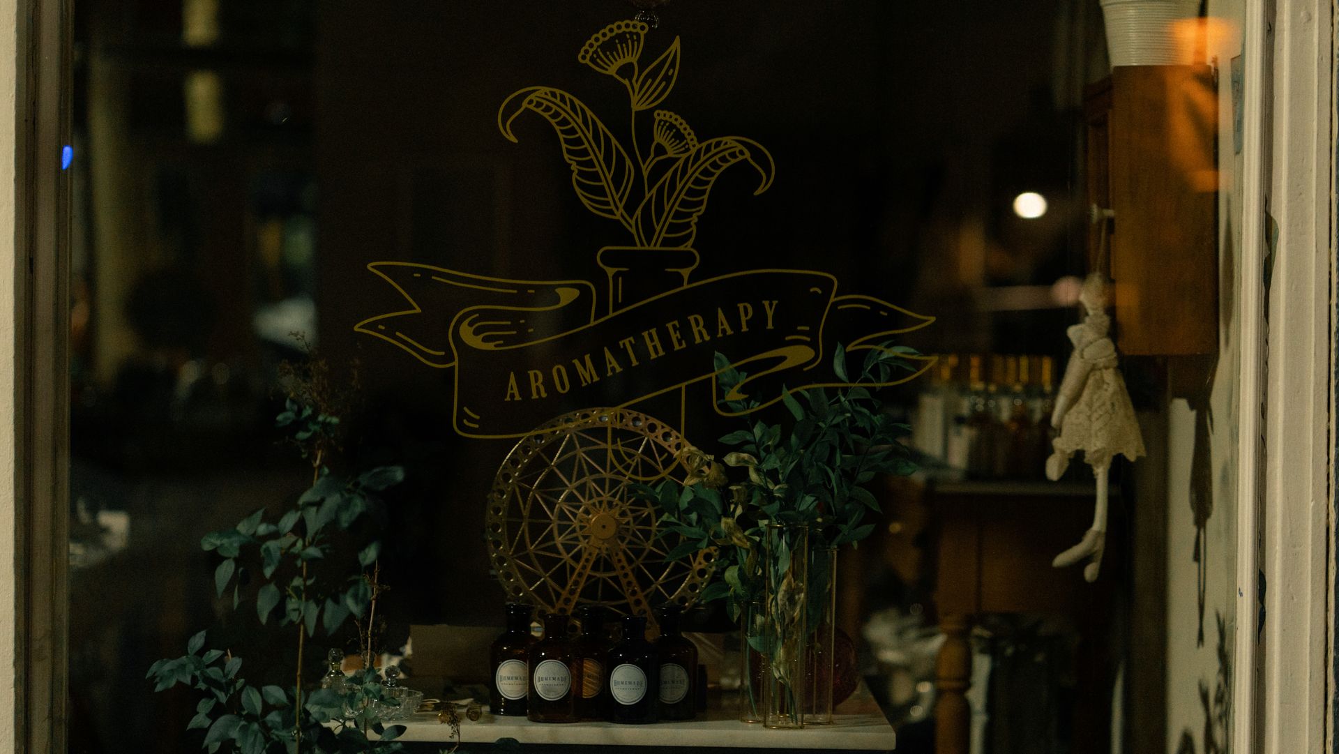 Elegant aromatherapy products are displayed in a cozy Istanbul shop window, accentuated by soft lighting.