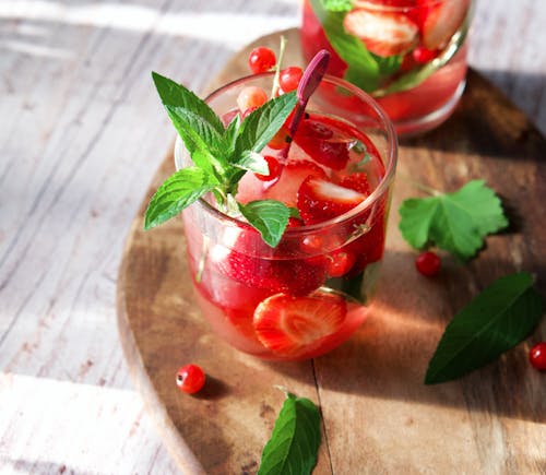 Red Fruit Drink with Mint Leaves on Wooden Cutting Board