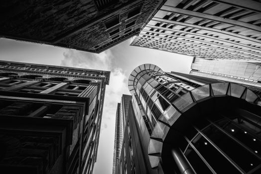 Striking monochrome photo of urban skyscrapers viewed from below, showcasing architectural grandeur.