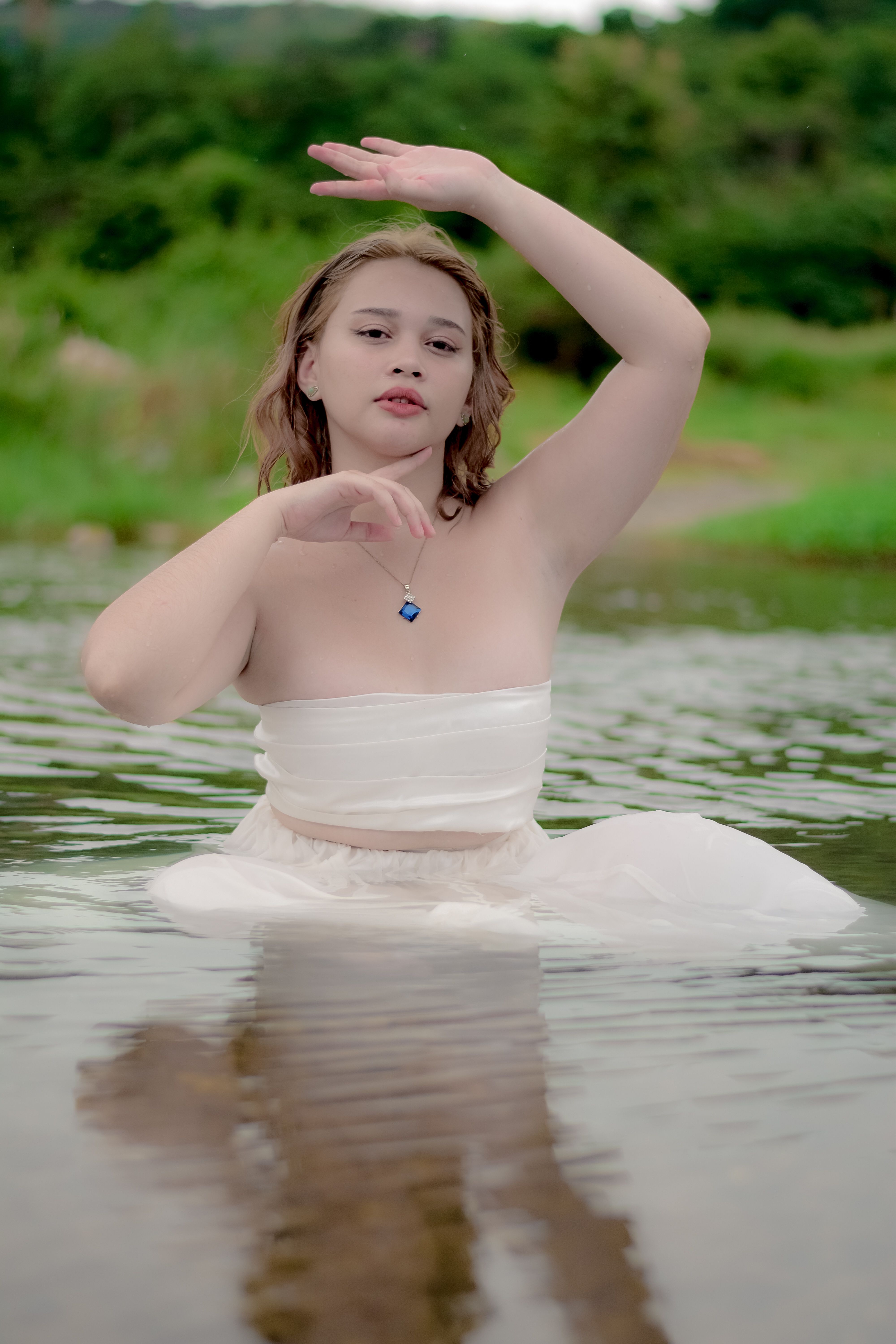 Posed Photo of a Young Woman in a White Dress Standing in Water and ...