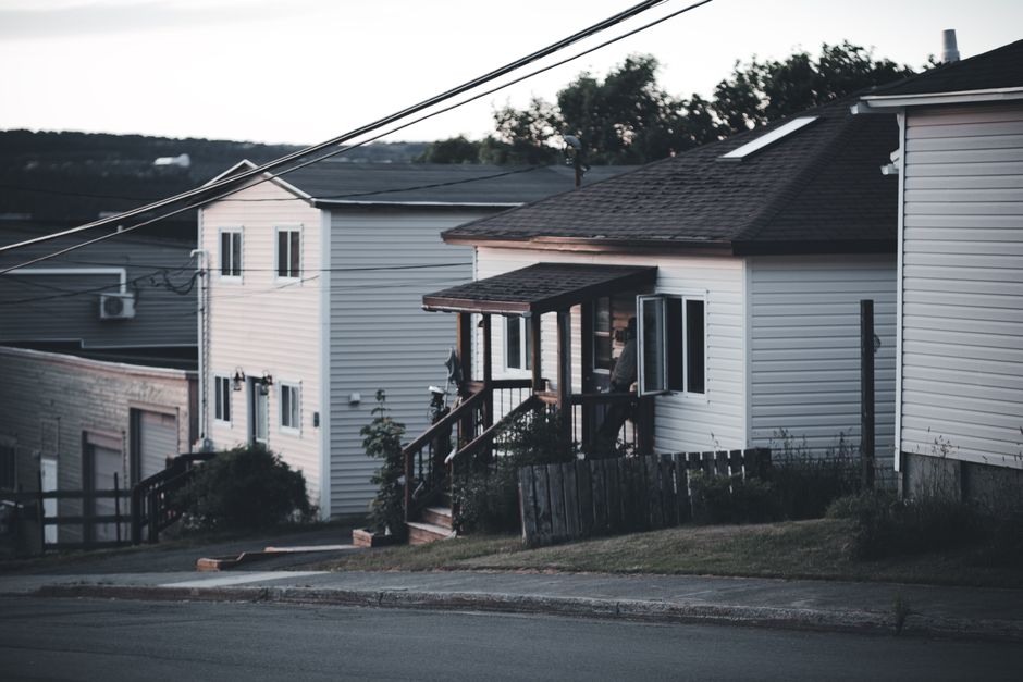 quiet suburban street at dusk with a single porch light on