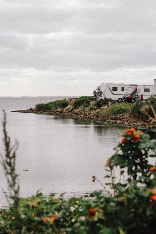 Free A peaceful camper van site by Dänemark's rocky coastline, ideal for a serene getaway. Stock Photo