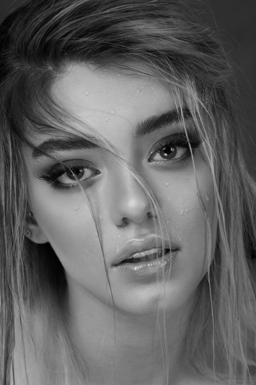 Free Close-up monochrome portrait of a woman with wet hair and water droplets on her face. Stock Photo
