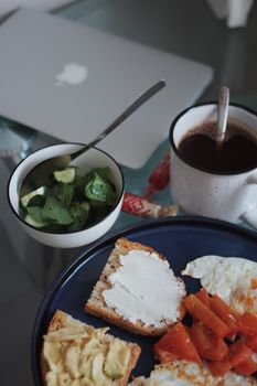 Top view of nutritious breakfast with toast, avocado, coffee, and salad for a healthy start.