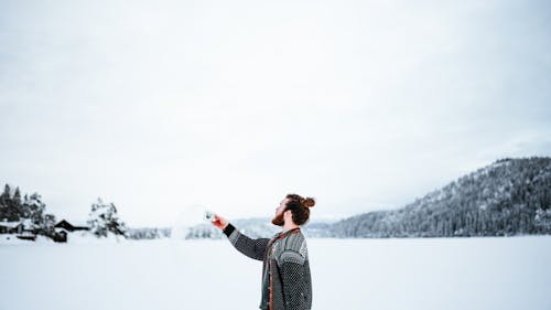 Free Man Standing Outside in Winter and Throwing Water From a Cup  Stock Photo
