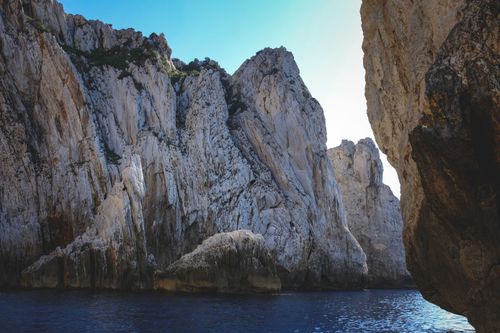 Free Majestic cliffs over deep blue ocean with clear sky. A serene and awe-inspiring nature scene. Stock Photo