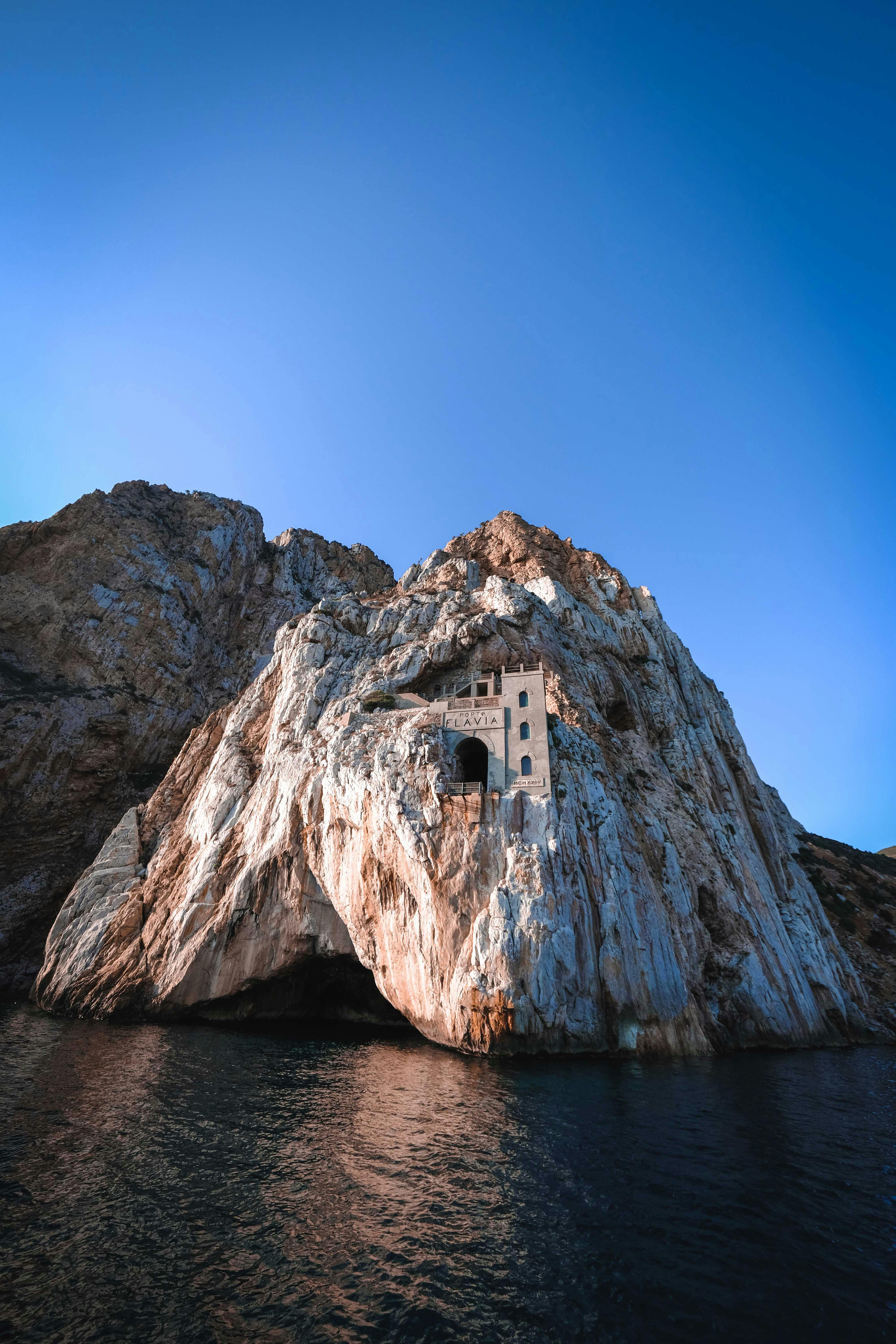 a cave in a brown rock formation on sea