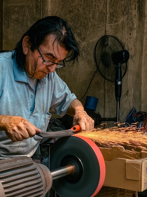 Man Sharpening a Knife with a Grinder